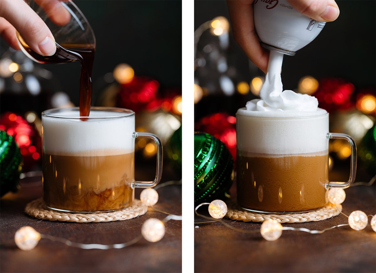 Syrup being poured into a glass mug with espresso and frothy milk topped with whipped cream.