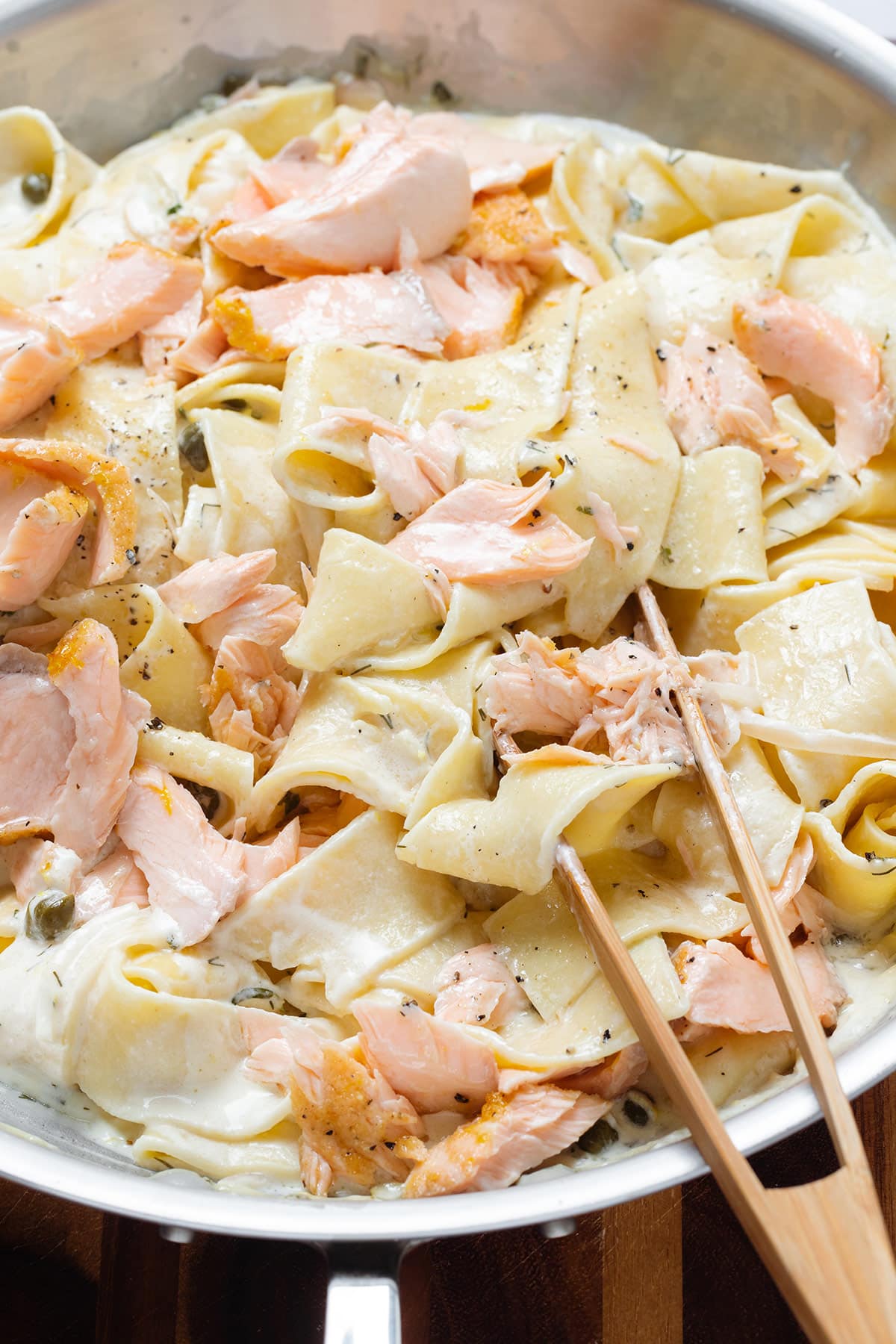 Pappardelle with a creamy sauce and roasted salmon in a large skillet.