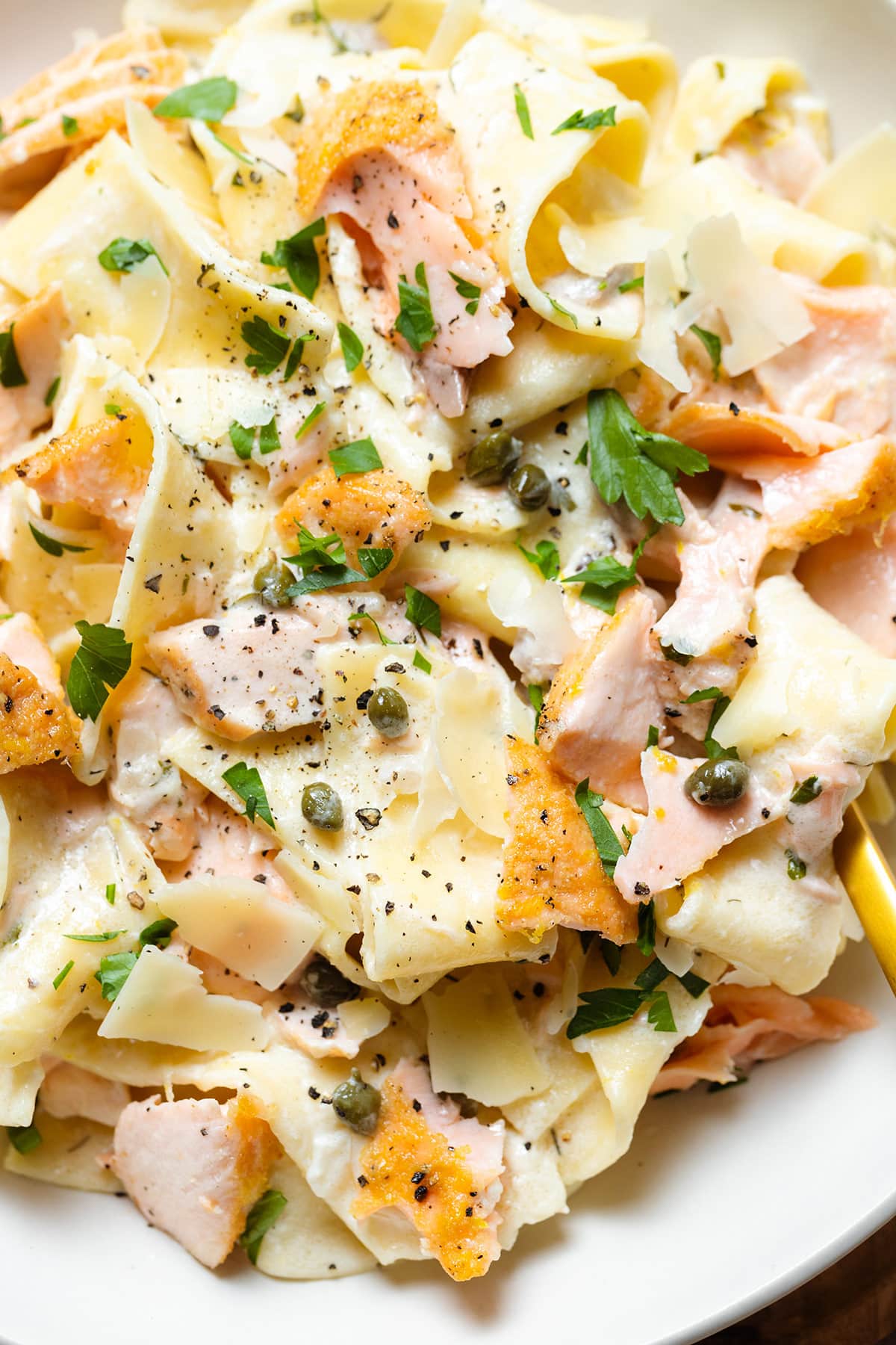 Pappardelle with roasted salmon, creamy white sauce, black pepper, and fresh herbs.