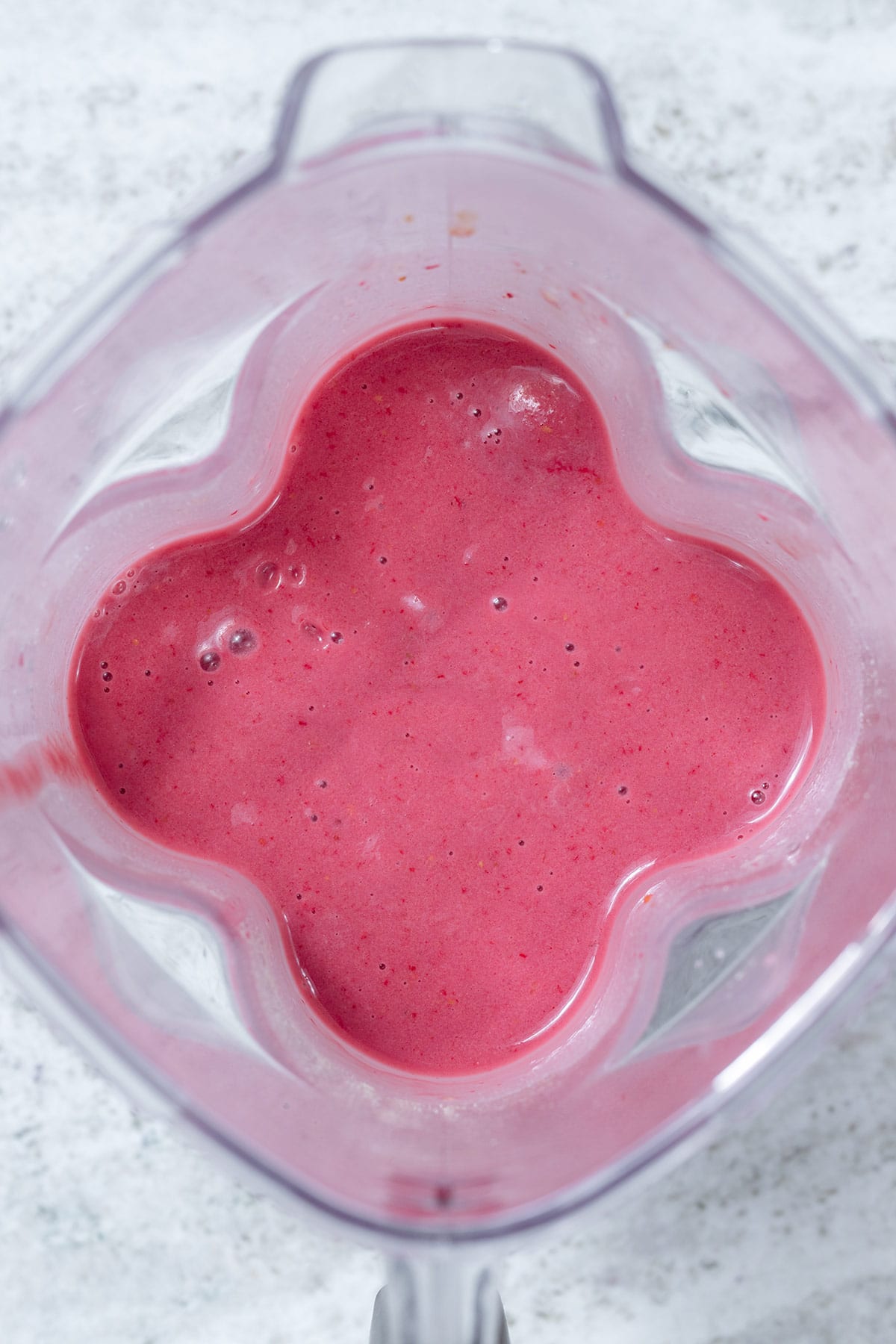 Creamy pink smoothie in a blender.