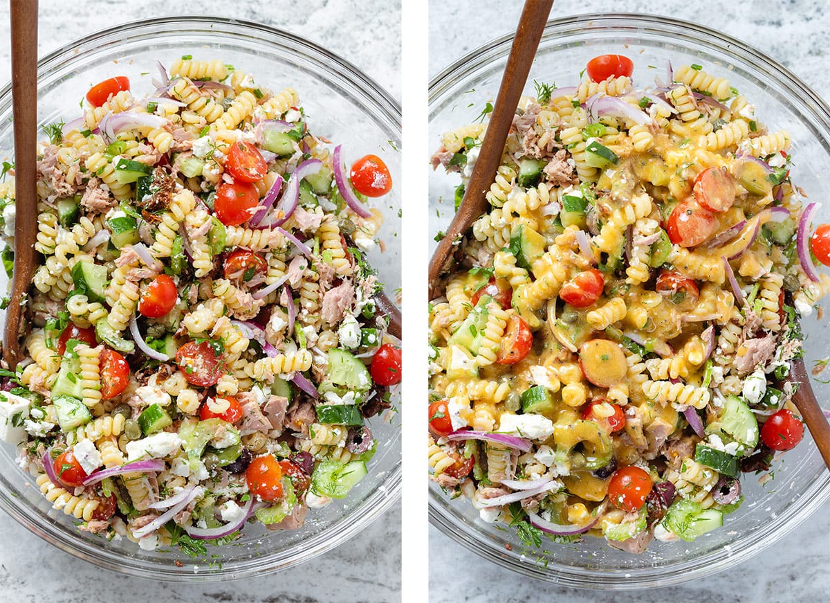 Colorful tuna pasta salad in a large glass bowl with wooden serving spoons.