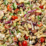 Close up of pasta salad with tuna, veggies, feta, and olives.