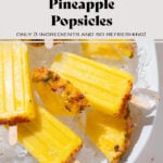 Pineapple popsicles with tajin on a large serving platter with ice and fresh pineapple slices.