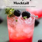 Bright red blackberry mocktail with seltzer on top creating an ombre effect in a short glass garnished with blackberries and fresh thyme.
