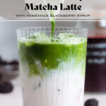 Matcha being poured over ice, milk, and blackberries into a tall glass.