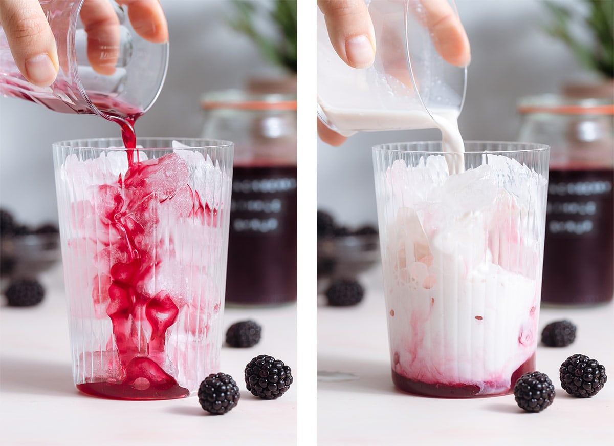 Blackberry syrup and almond milk being poured over ice into a tall glass.
