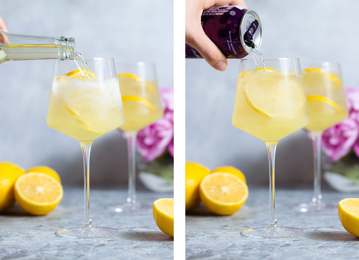 Prosecco and seltzer being poured into a stem glass over ice garnished with lemon slices.