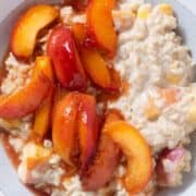 Peach oatmeal with caramelized peaches on top in a a grey bowl.