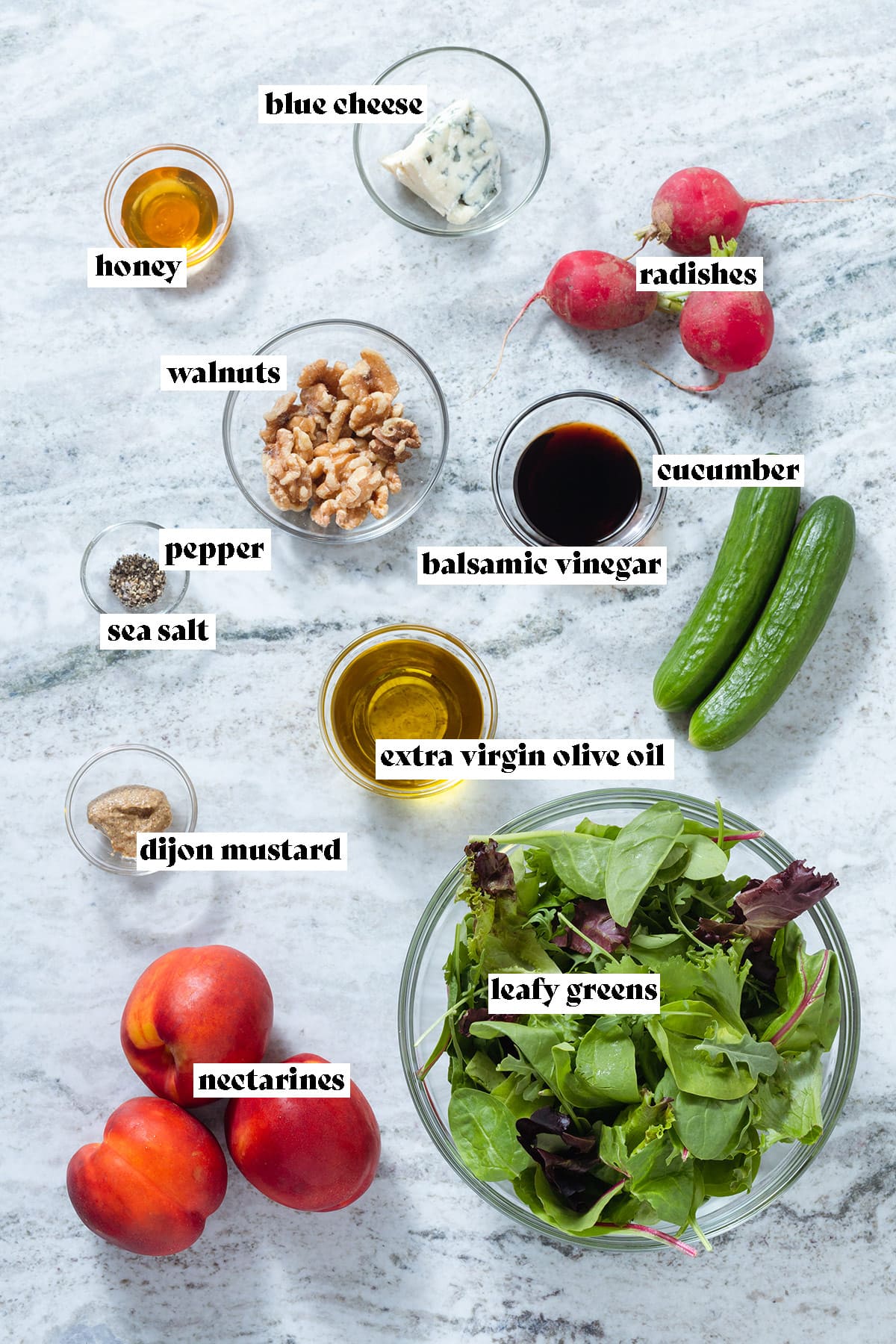 Ingredients like nectarines, mixed greens, cucumbers, radishes, and condiments in glass bowls laid out on a grey stone background with text overlay.
