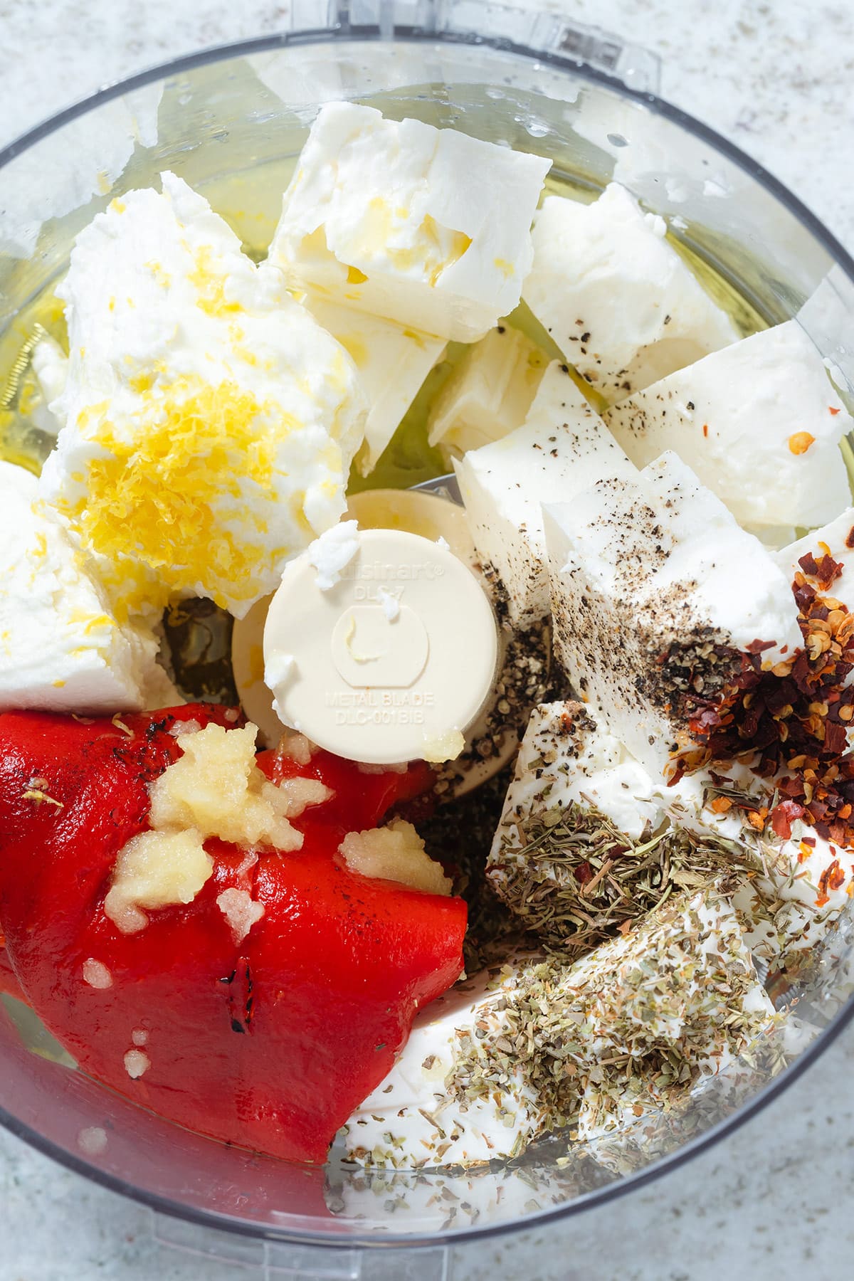 Feta, goat cheese, roasted red pepper, and other ingredients in a food processor.