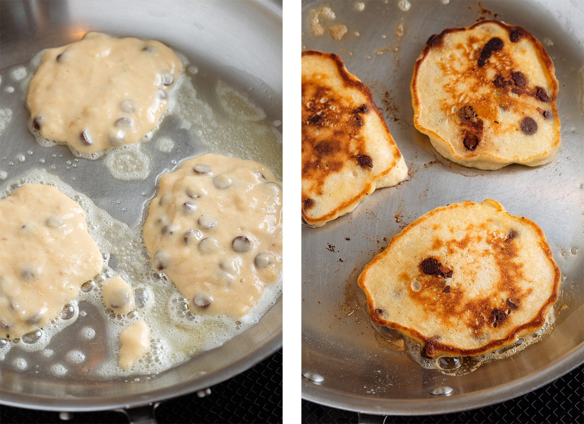 Chocolate chip pancakes cooking in a large stainless steel pan with melted butter.