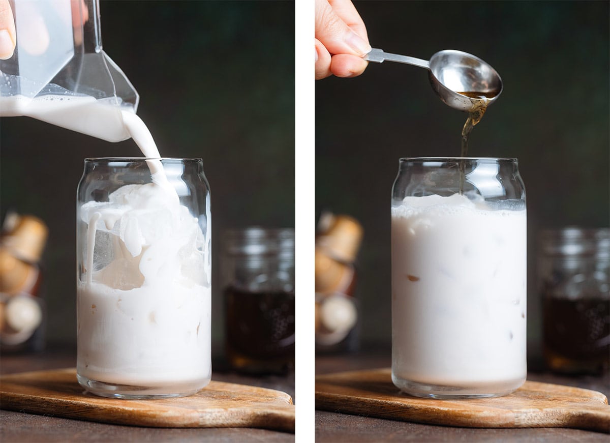 Milk and vanilla syrup being poured over ice into a glass that looks like a can on a wooden background.