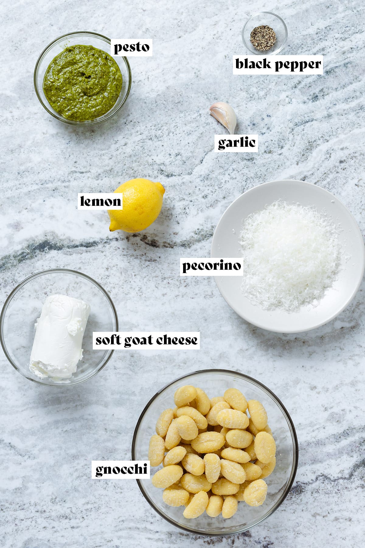 Gnocchi, pesto, cheese, lemon, garlic, and pepper all measured and laid out with text overlay.