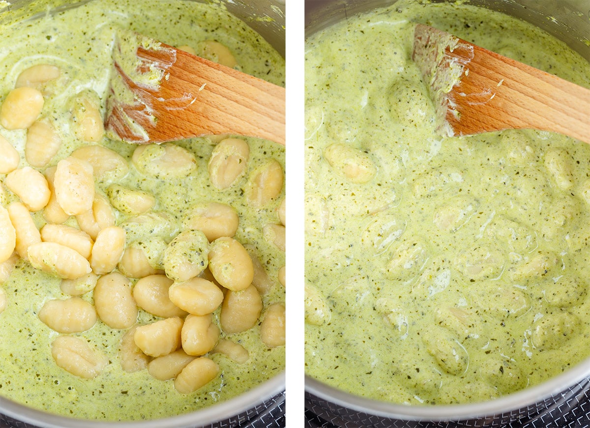 Cooked gnocchi being mixed with cheesy pesto sauce in a large pot.