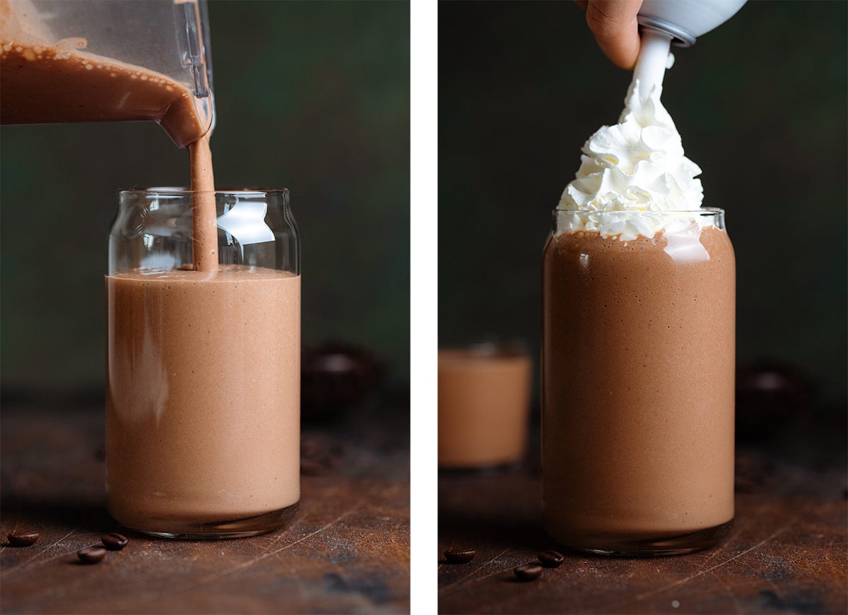 Mocha smoothie being poured into a tall glass and being garnished with whipped cream on a dark wooden background.