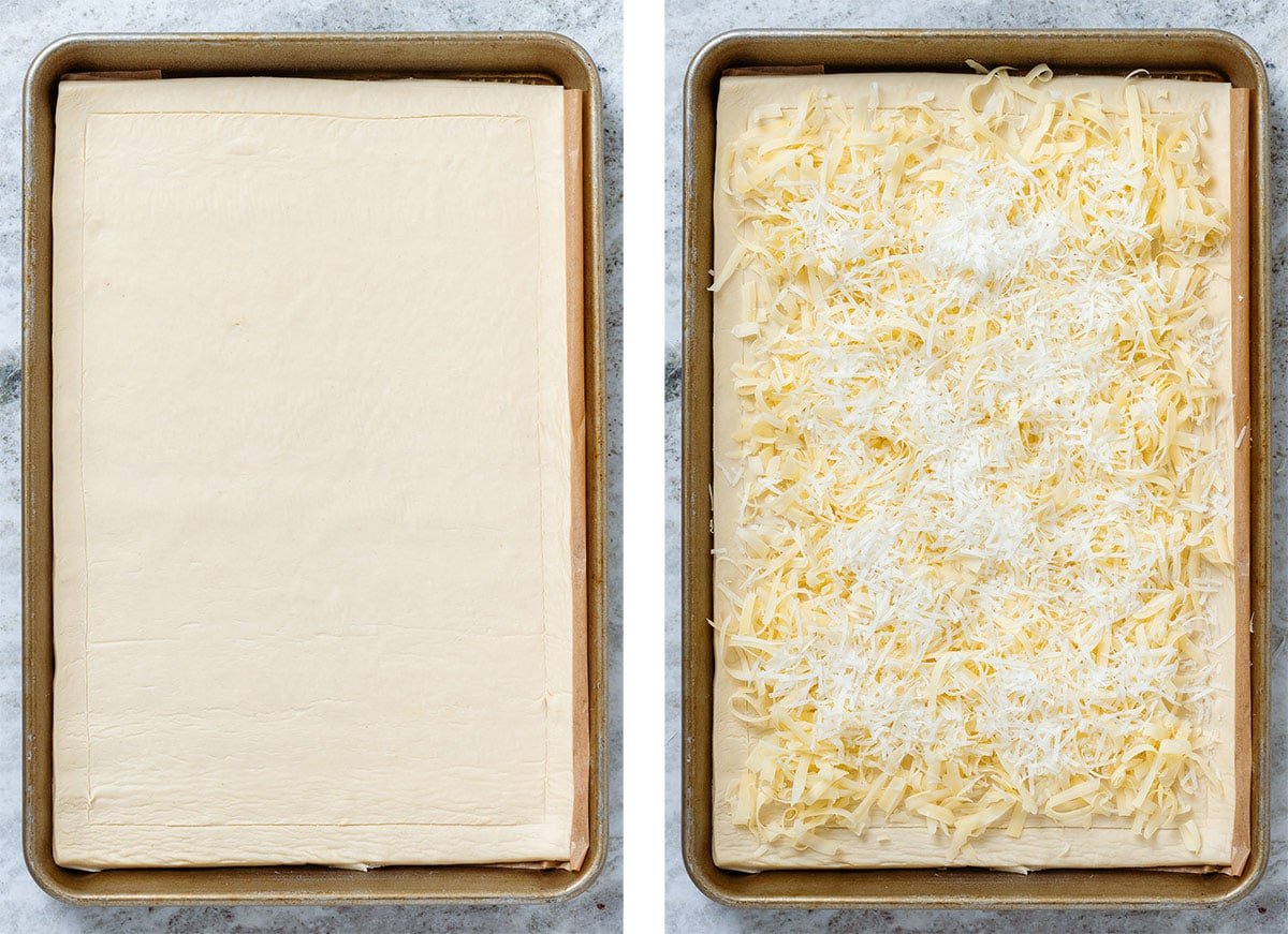 Puff pastry sheet on a baking sheet and parchment paper topped with shredded cheese.