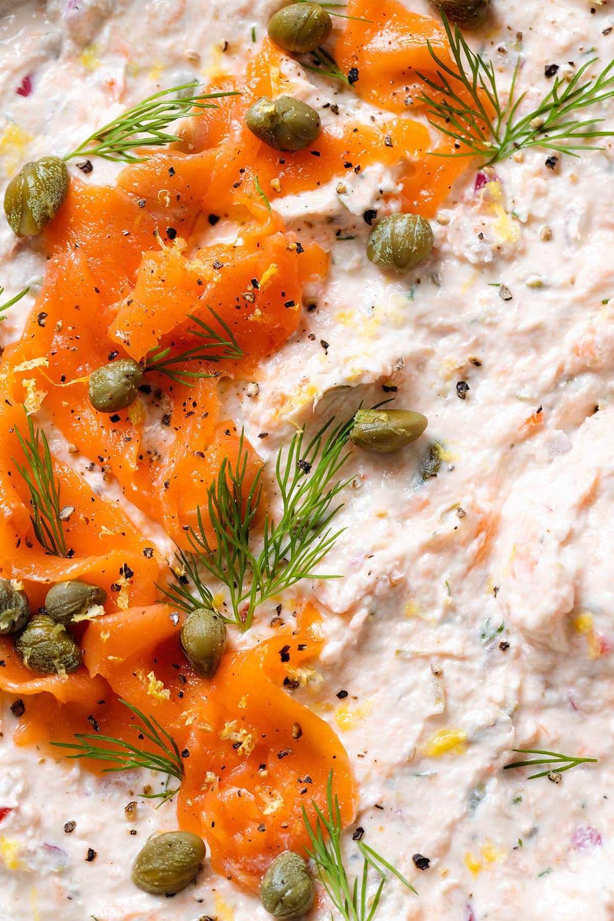 Smoked salmon dip garnished with more smoked salmon, capers, and fresh dill.