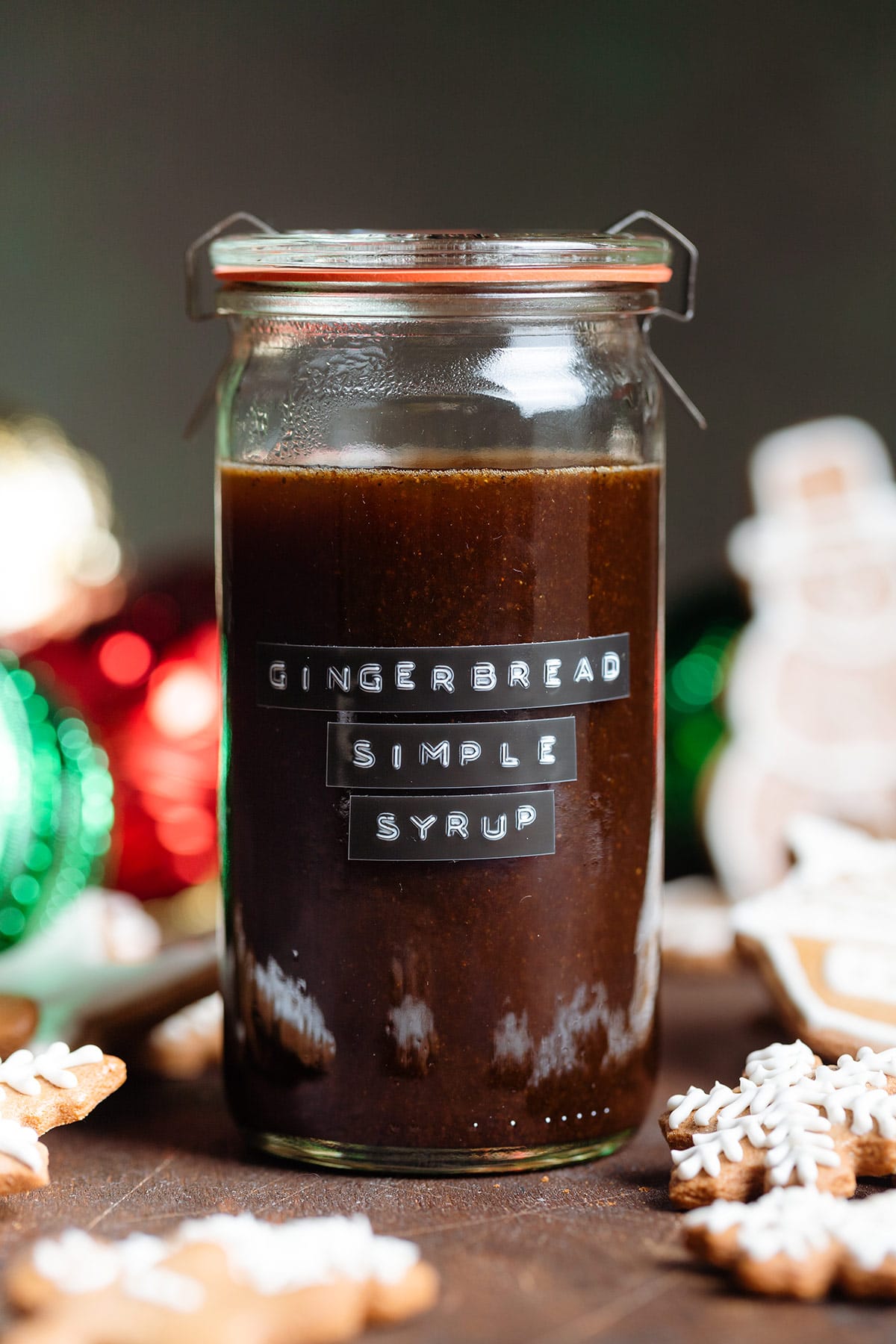 Dark brown syrup in a glass jar with an embossed gingerbread simple syrup label.