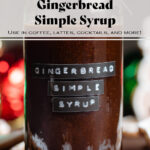 Dark brown syrup in a glass jar with an embossed gingerbread simple syrup label.