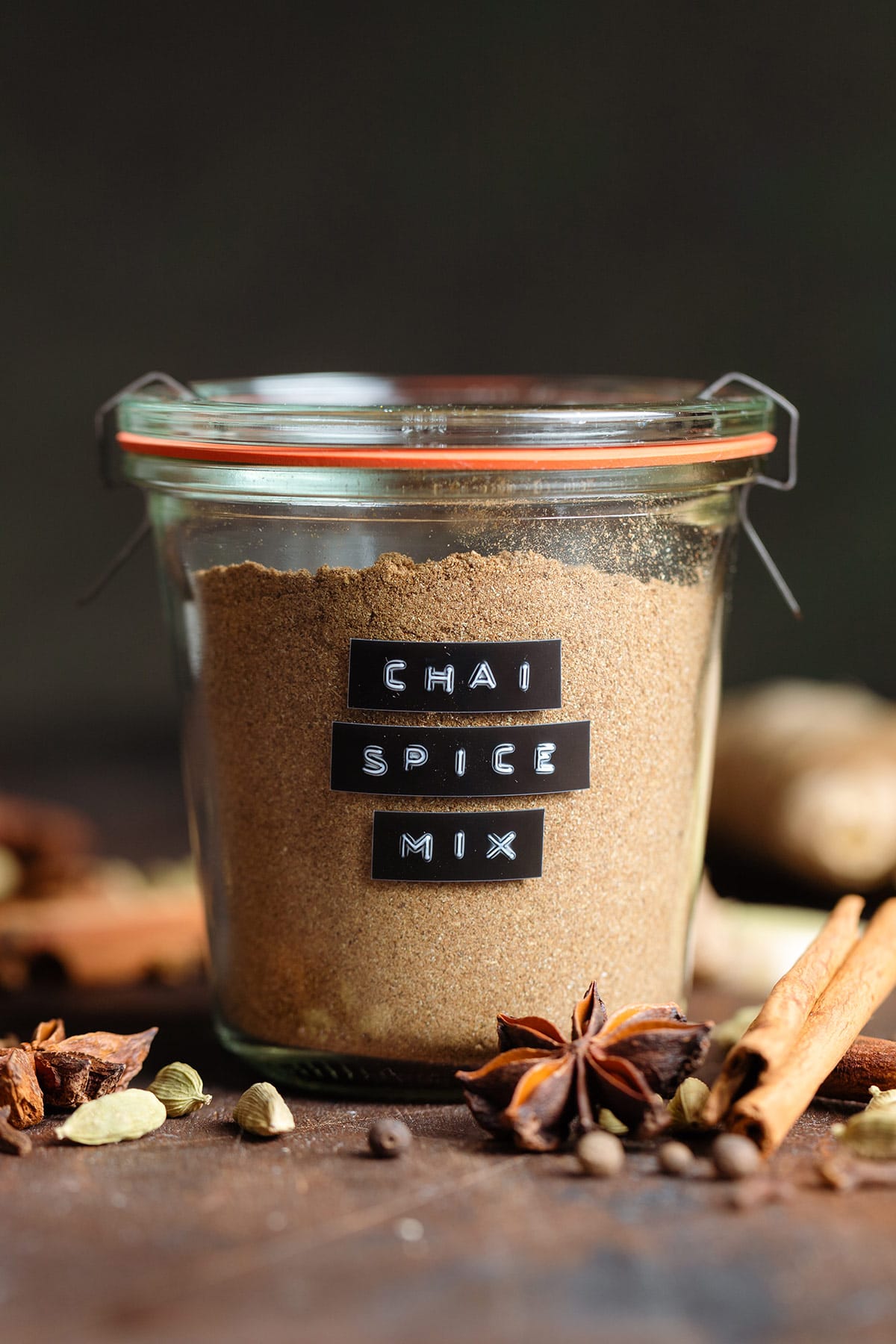 Chai spice mix in a glass jar with a black embossed label on the side.