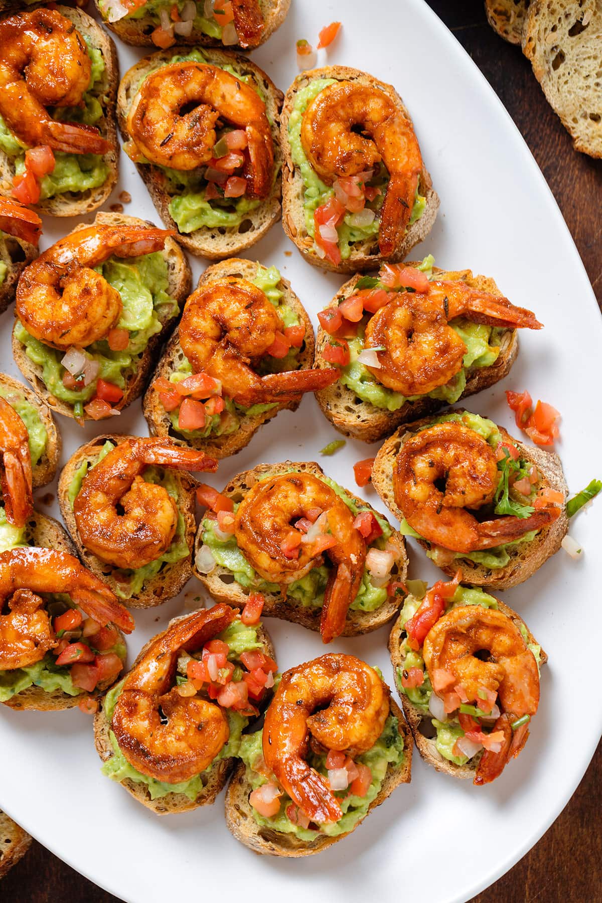 Toasted baguette slices topped with guacamole, fresh salsa, and cajun shrimp.