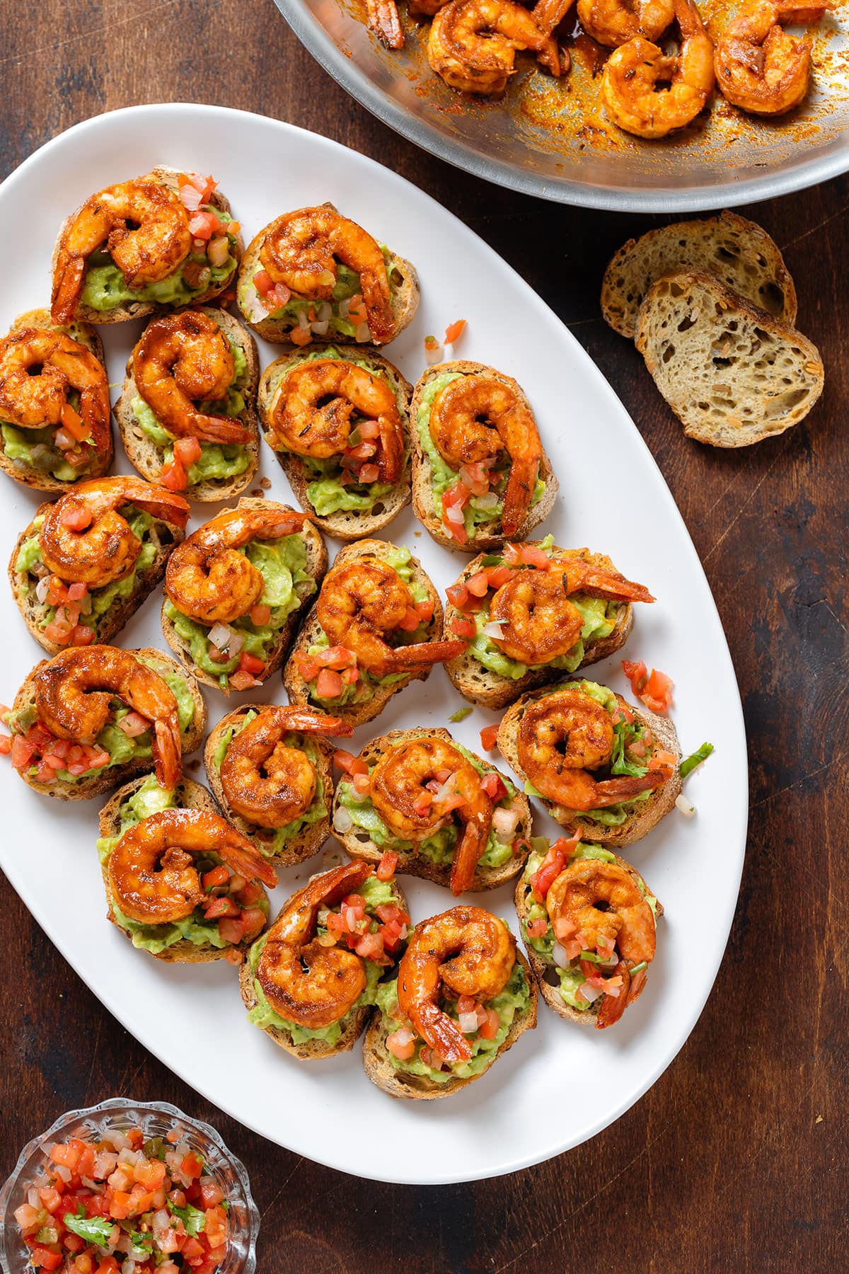 Toasted baguette slices topped with guacamole, fresh salsa, and cajun shrimp.