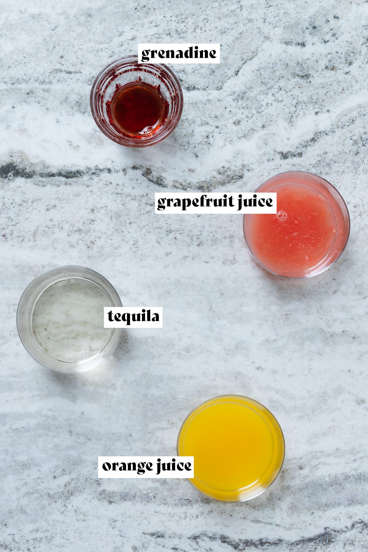 Orange juice, grapefruit juice, tequila, and grenadine measured out in small glasses.