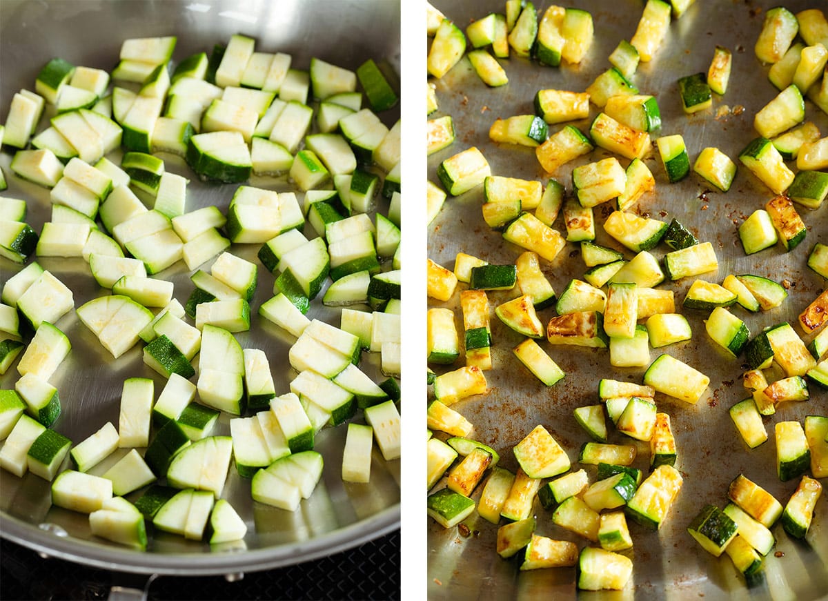 Diced zucchini cooking in a large stainless steel pan.