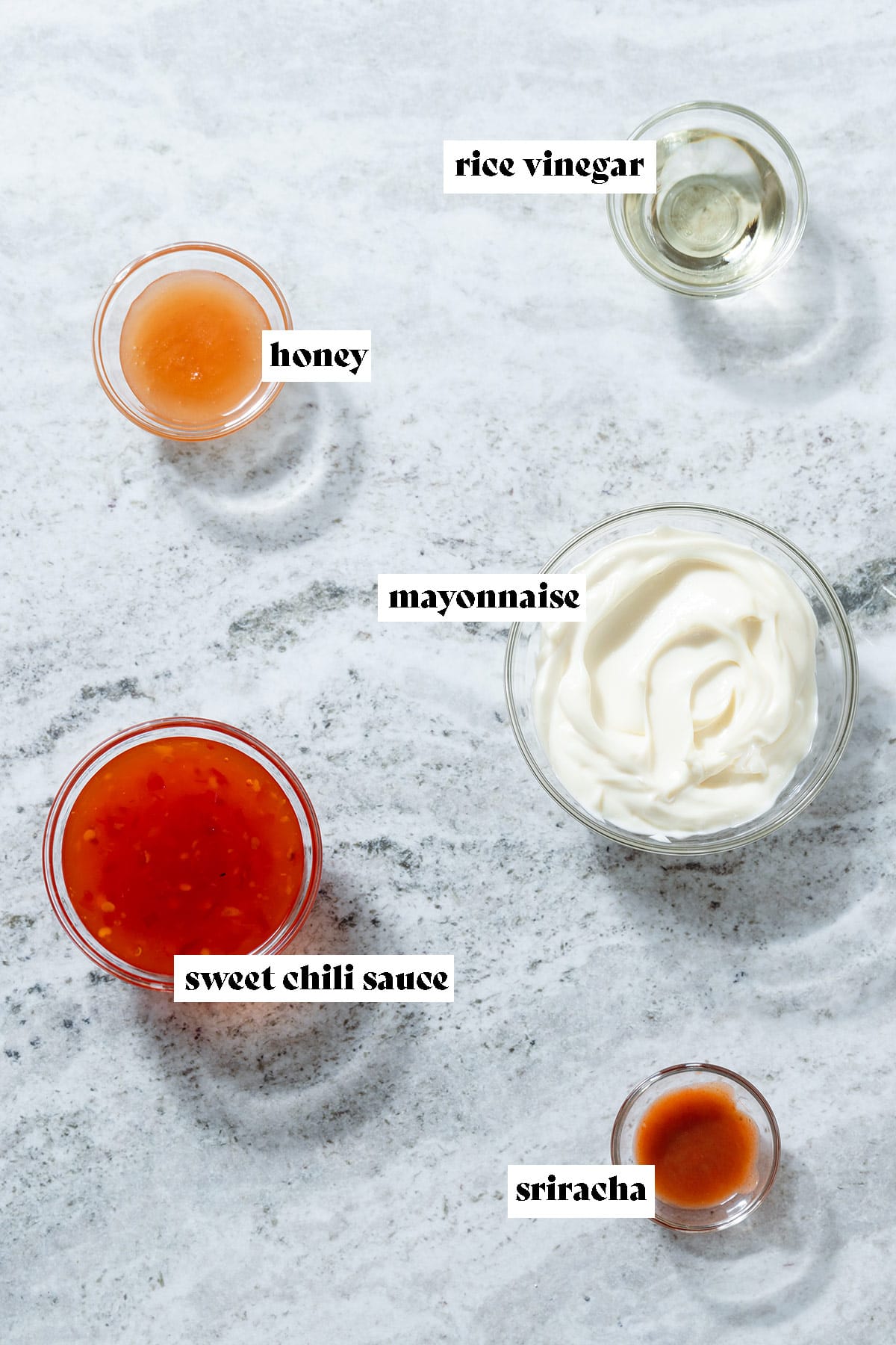 Measured ingredients in small bowls like mayonnaise, sweet chili sauce, sriracha, and honey with text overlay.