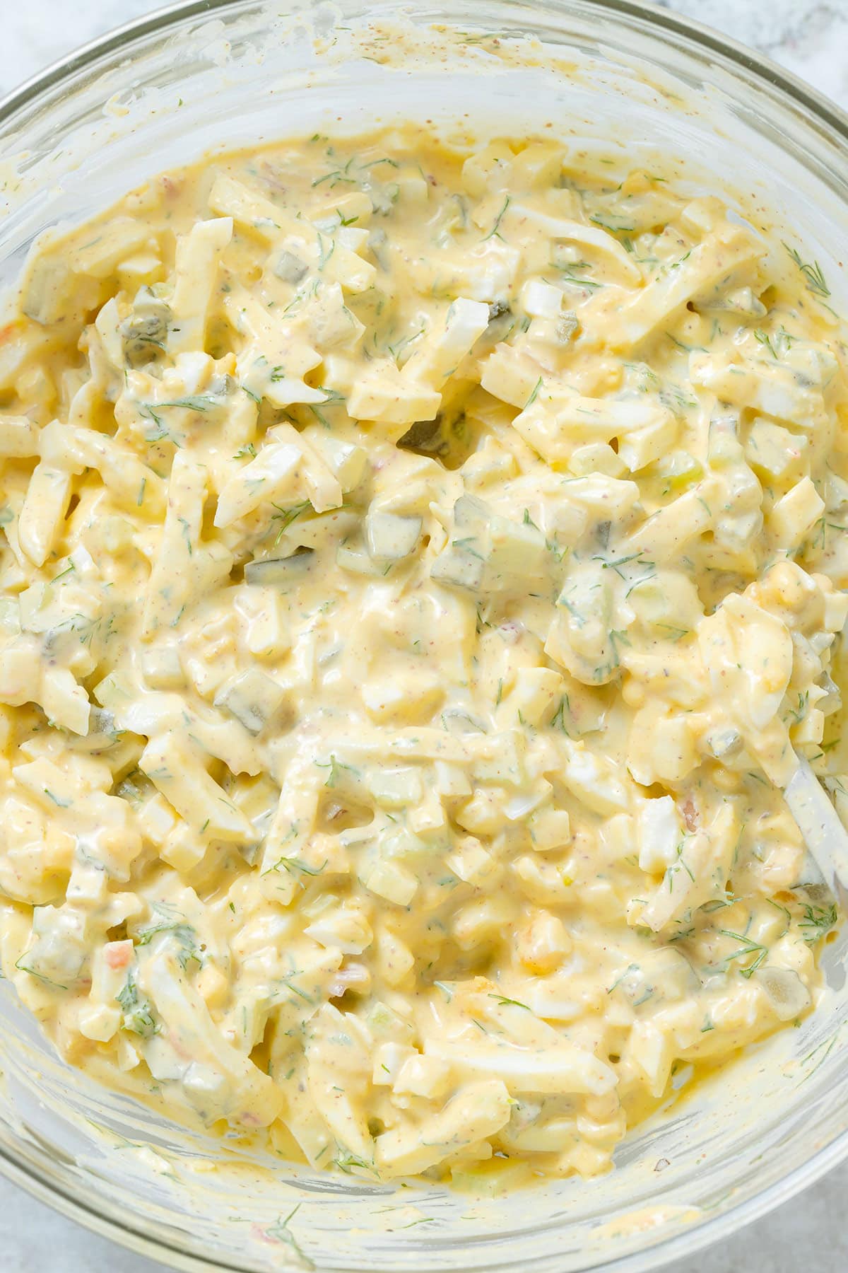 Creamy egg salad in a large glass bowl.