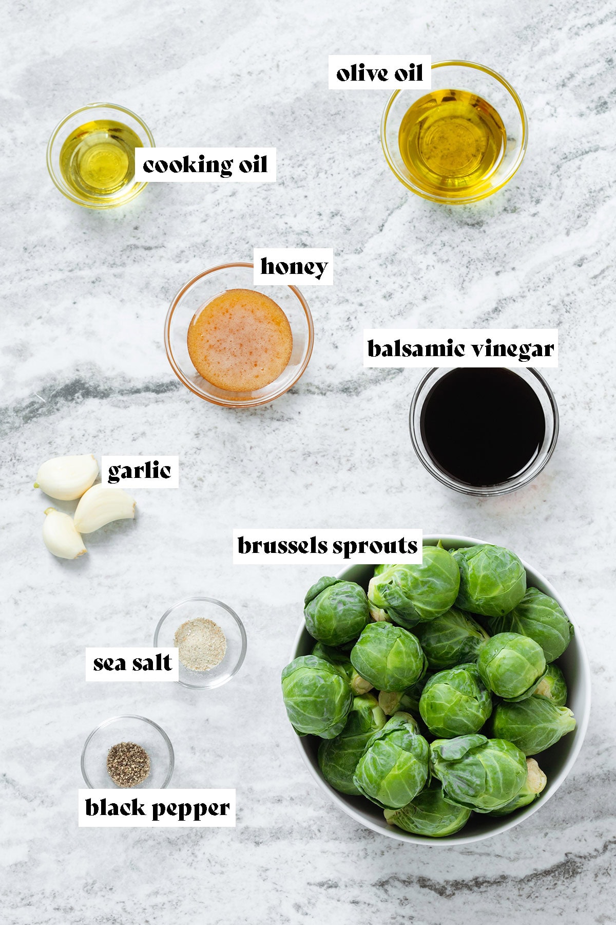 Brussels sprouts, balsamic vinegar, honey, garlic, cooking oil, and other ingredients all laid out in small bowls.