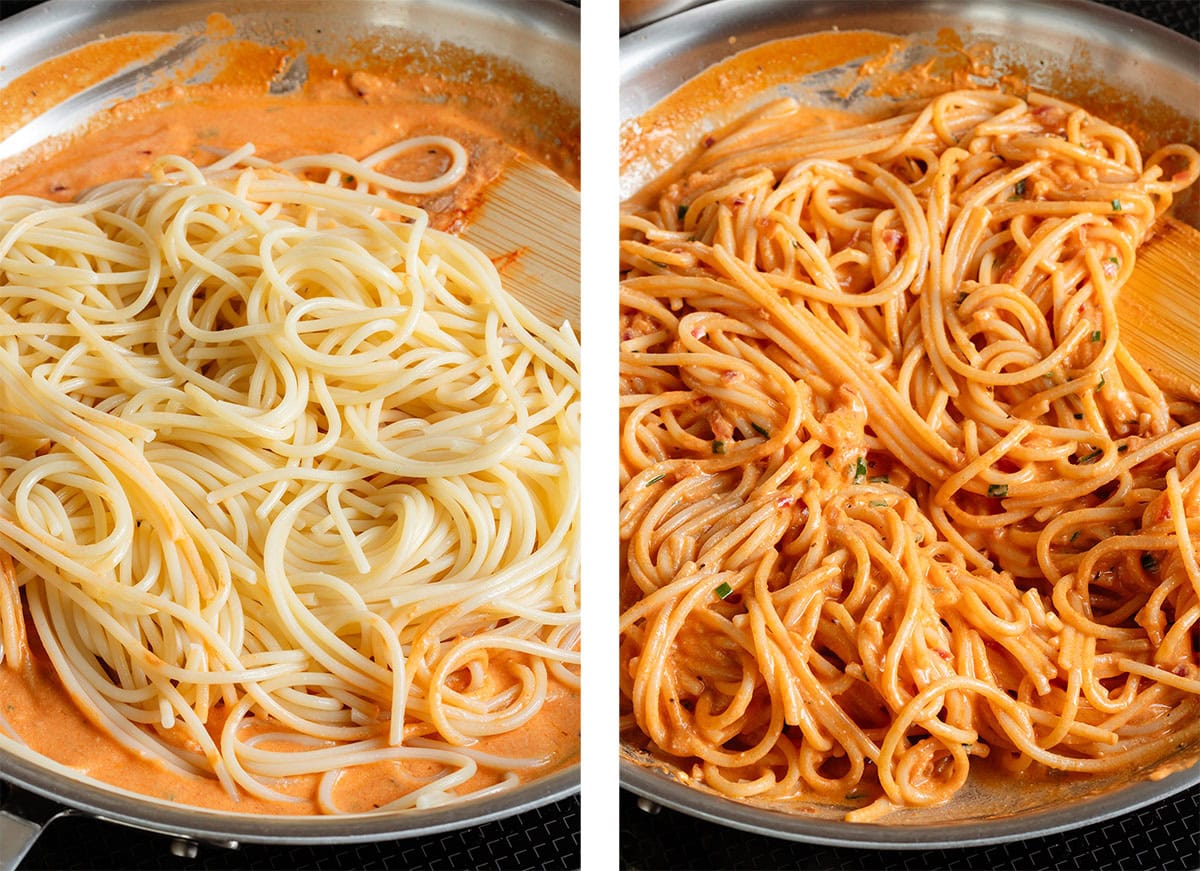 Spaghetti being tossed with creamy orange sauce in a large stainless steel pan.