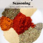 Spices like paprika, oregano, thyme, garlic powder, and sea salt in a white bowl with an orange rim.