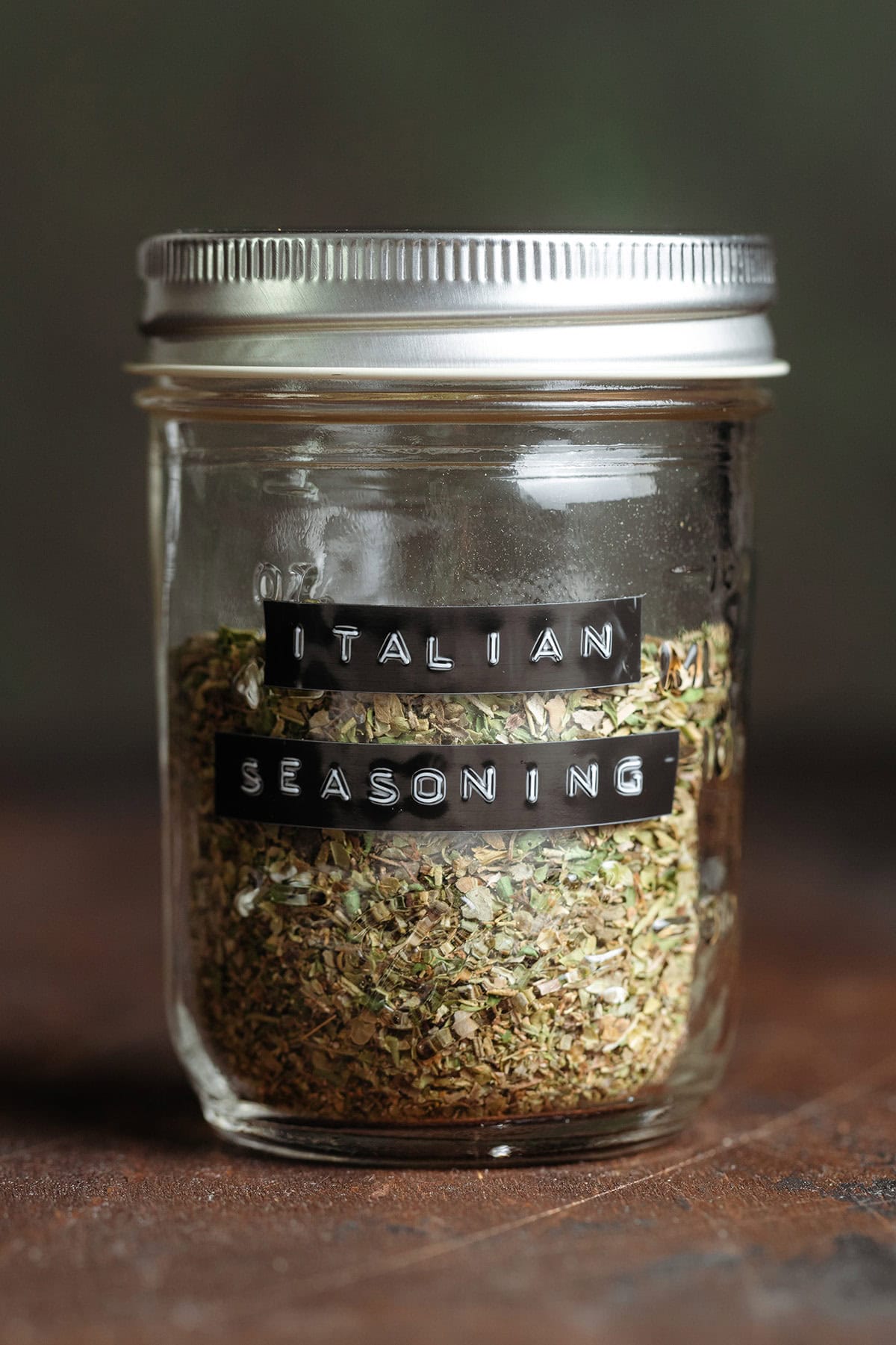 Mixed dry herb Italian seasoning in a glass jar with a black embossed label.