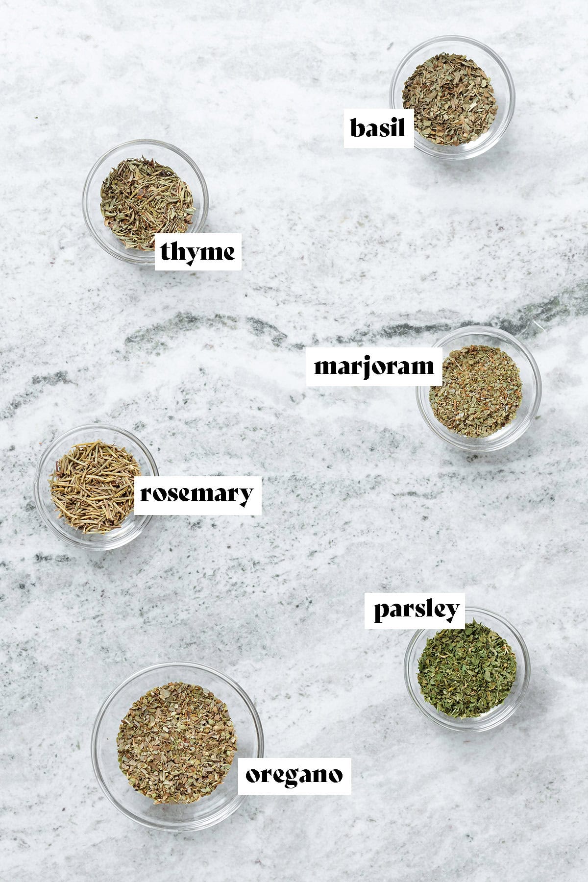 Dried herbs like rosemary, oregano, and parsley in small glass bowls with text overlay.
