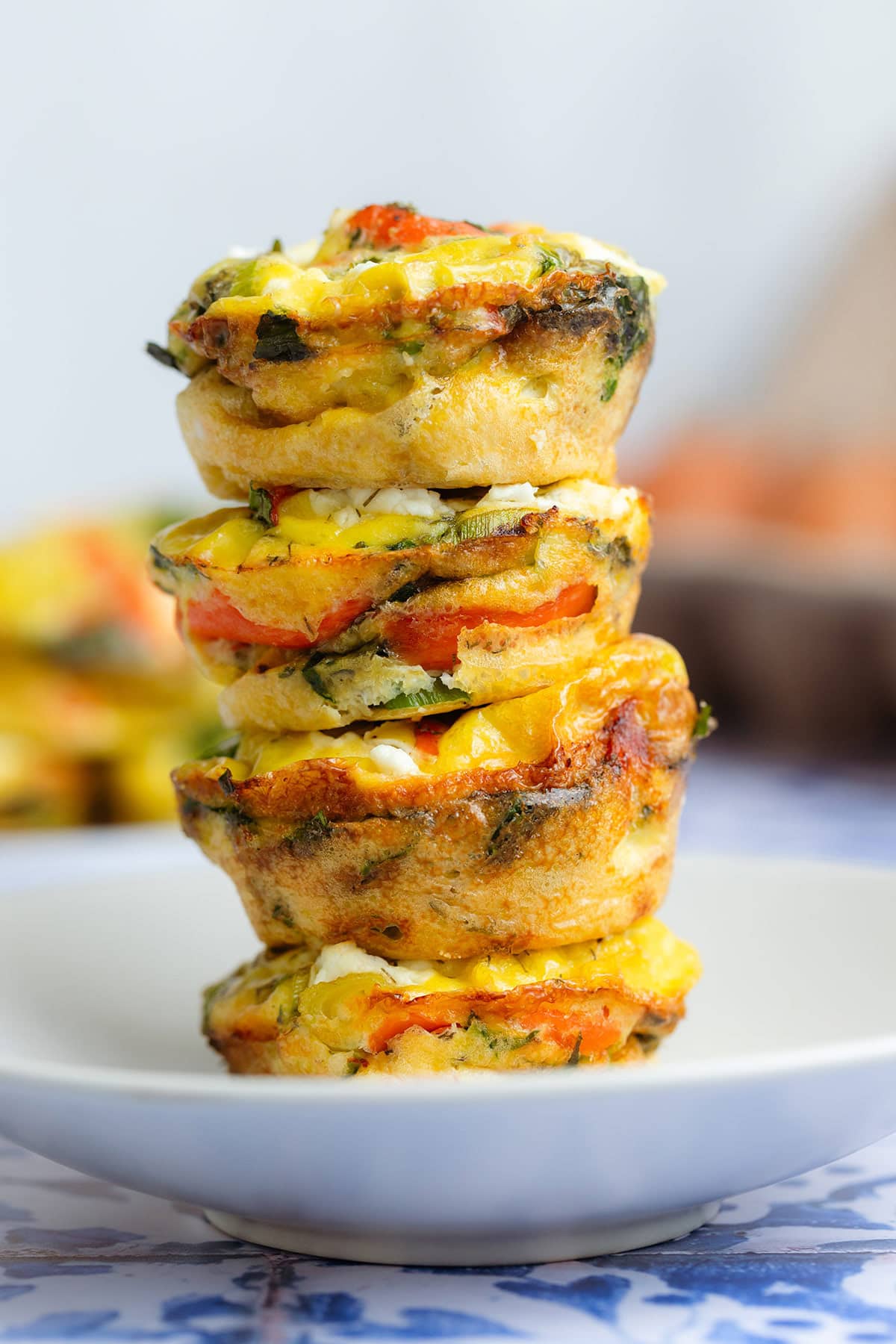 Four smoked salmon egg muffins stacked on a small white plate.