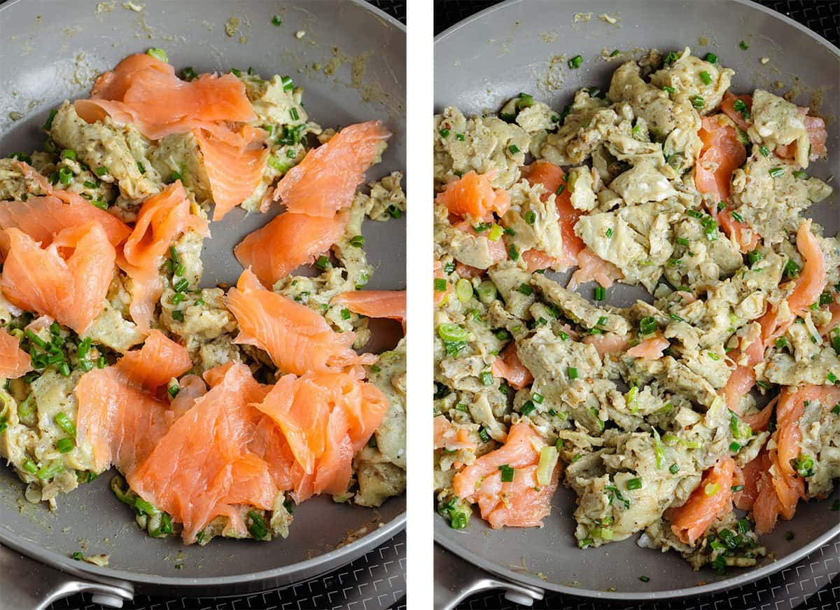Torn up cold smoked salmon being added to a pan with scrambled eggs.
