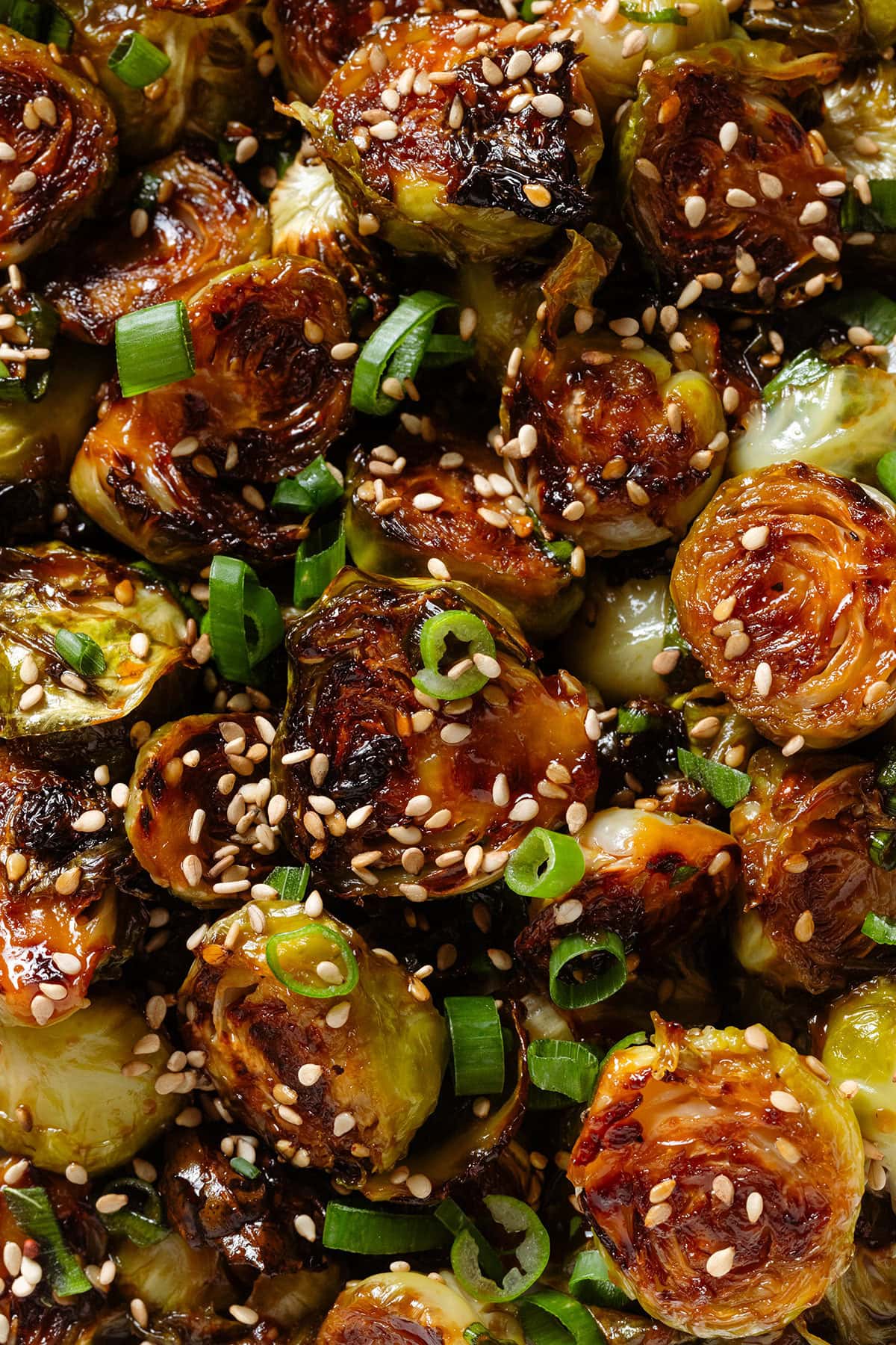 Roasted brussels sprouts with caramelized teriyaki sauce sprinkled with sesame seeds and green onion.