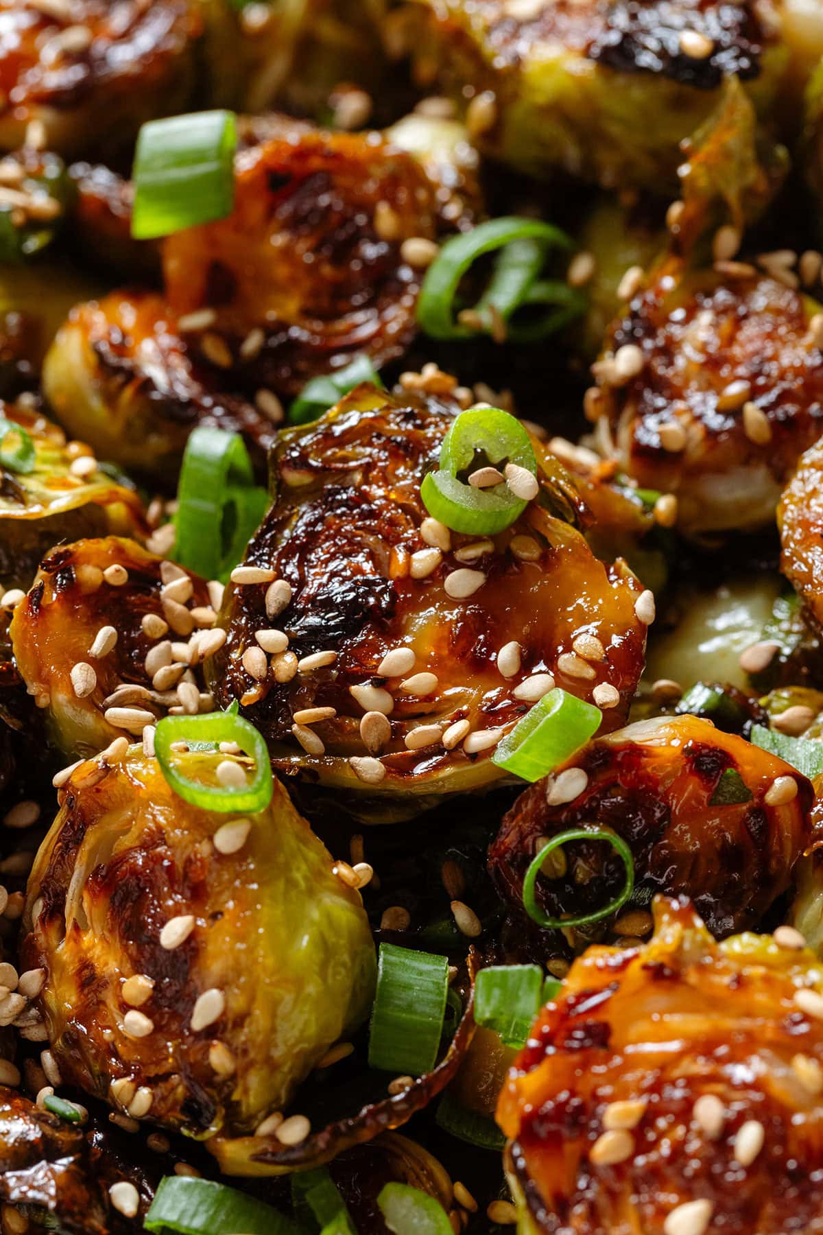 Roasted brussels sprouts with caramelized teriyaki sauce sprinkled with sesame seeds and green onion.