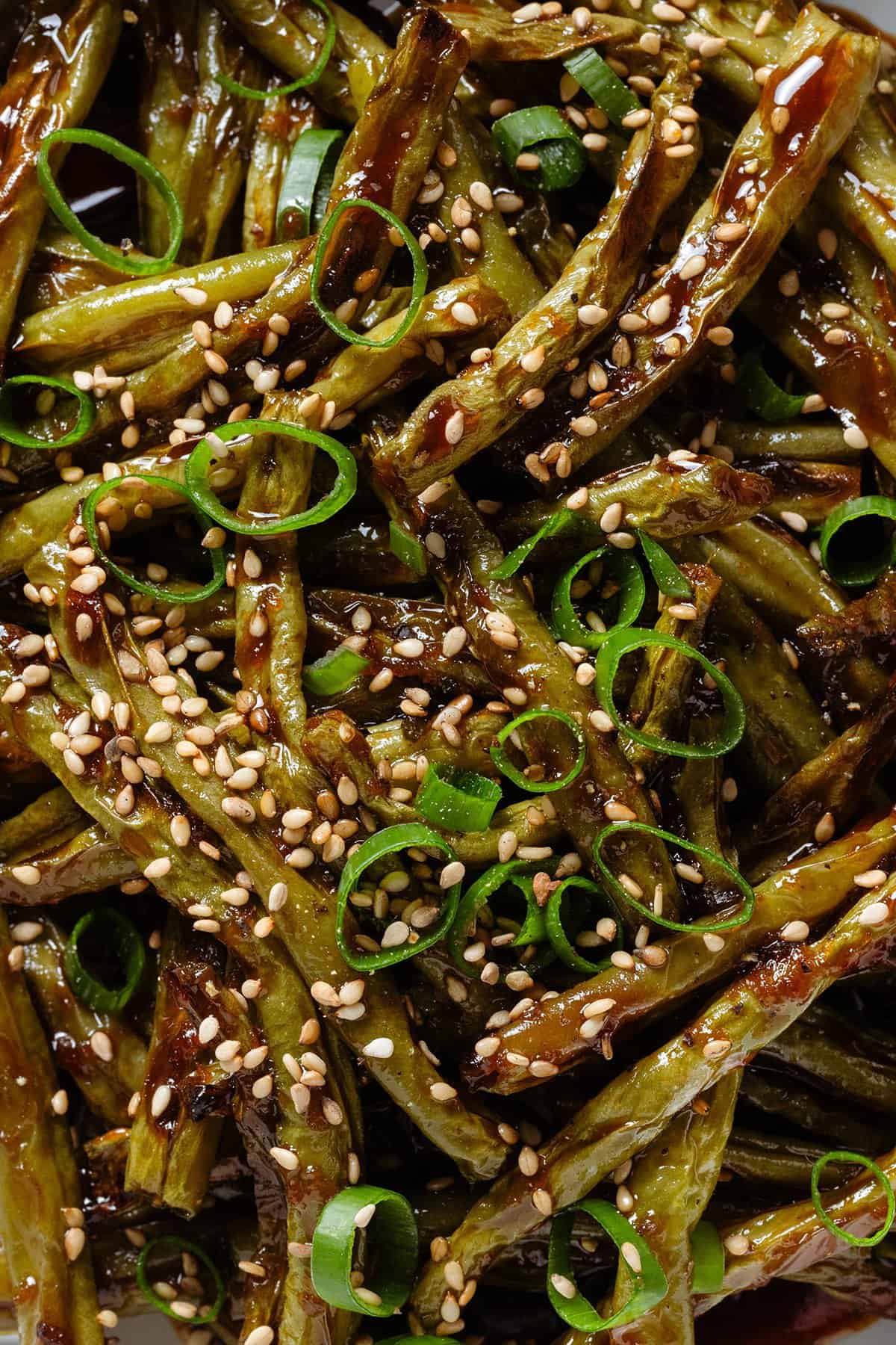 Roasted green beans with teriyaki sauce sprinkled with green onion and sesame seeds.