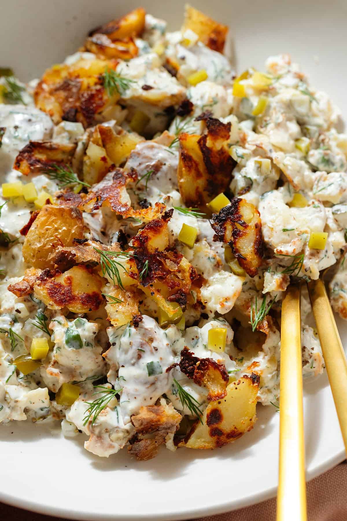Crispy potato salad with yogurt mayo dressing garnished with bit of more crispy potatoes.