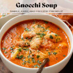 Creamy tomato gnocchi soup in a white bowl garnished with fresh herbs and parmesan.