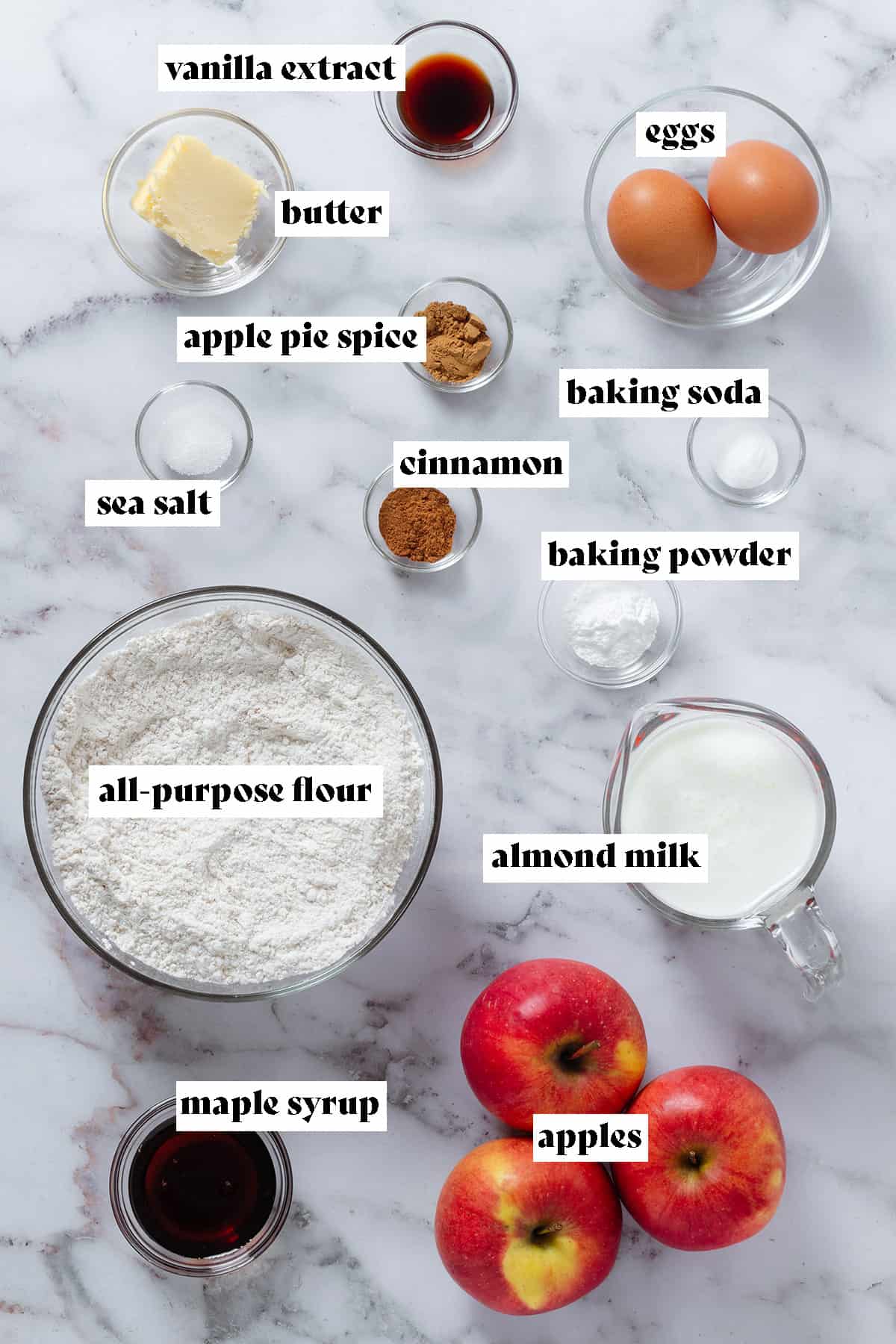Ingredients like apples, flour, milk, eggs, butter, and spices in small glass bowls with text overlay.