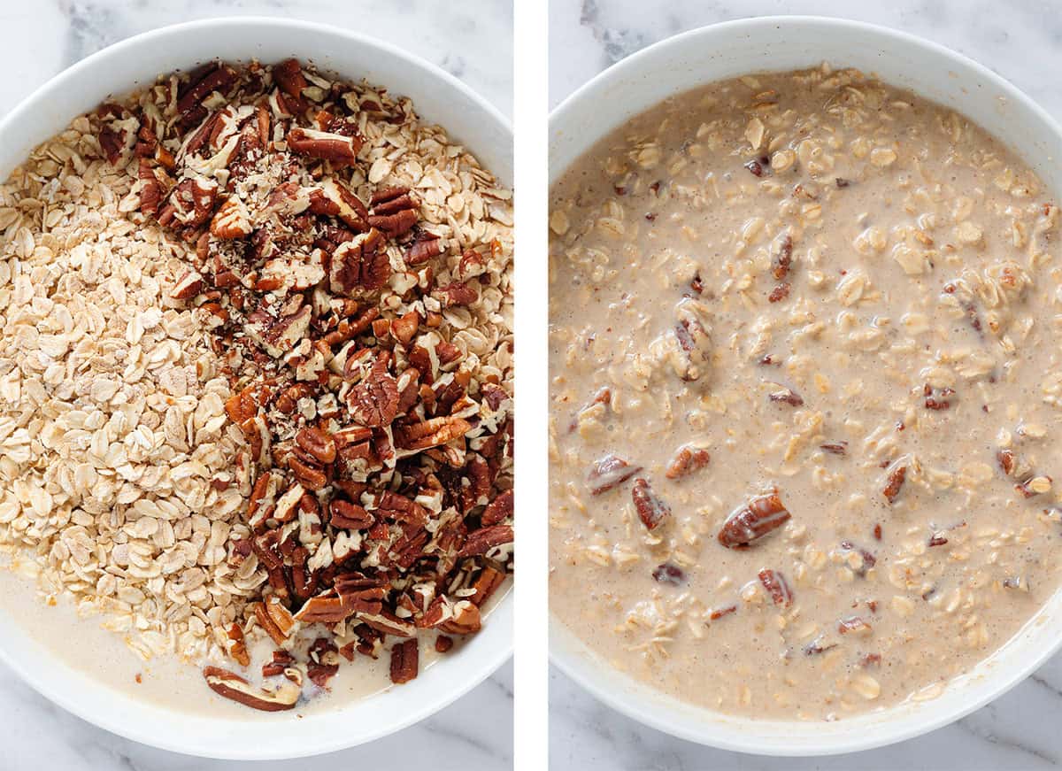 Oats, chopped pecans, and other dry ingredients being mixed into wet ingredients in a large white bowl.