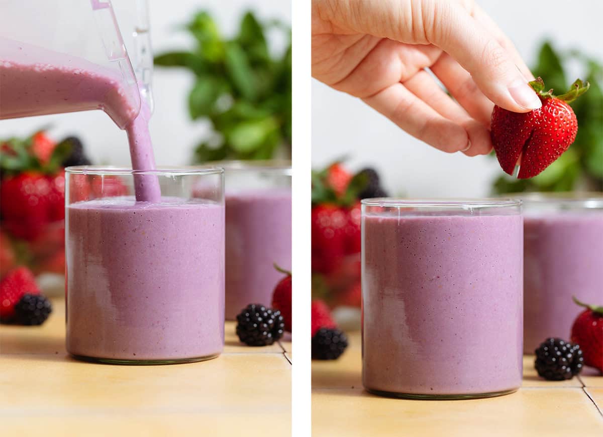 Purple blackberry smoothie being poured into a short glass and garnished with a strawberry.