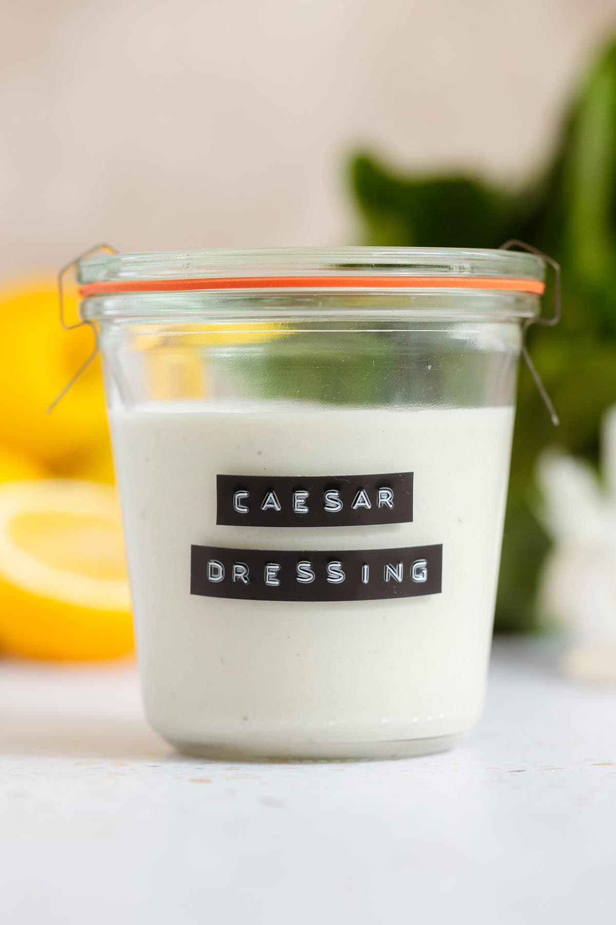 Caesar dressing in a small jar with a black and white embossed label.