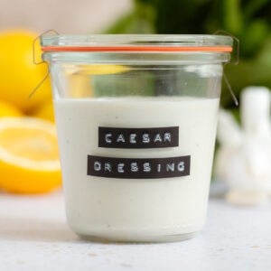 Caesar dressing in a small jar with a black and white embossed label.