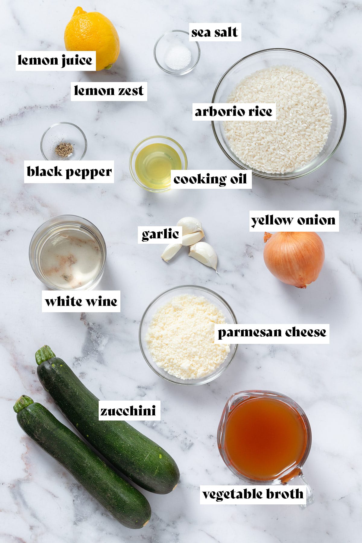 Zucchini, arborio rice, yellow onion, parmesan cheese, garlic, lemon, and other ingredients all laid out with text overlay.