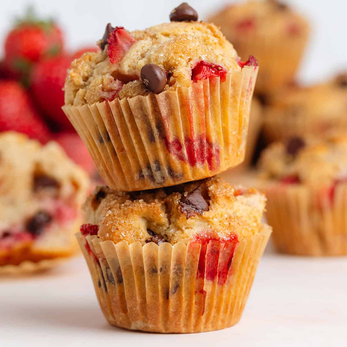 Two strawberry chocolate chip muffins stacked on top of each other.