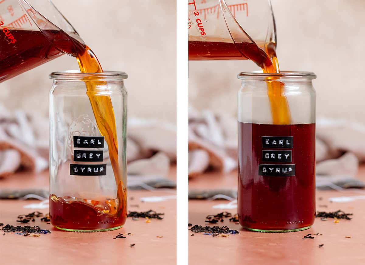 Dark brown syrup being poured into a tall glass jar with an embossed label that says "earl grey syrup".